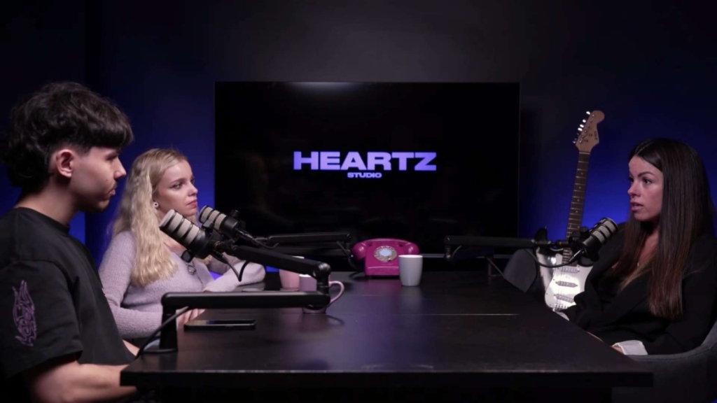 Estúdio Podcast no Porto com cenário base de mesa e cadeiras, em fundo preto, com televisão para apoio visual