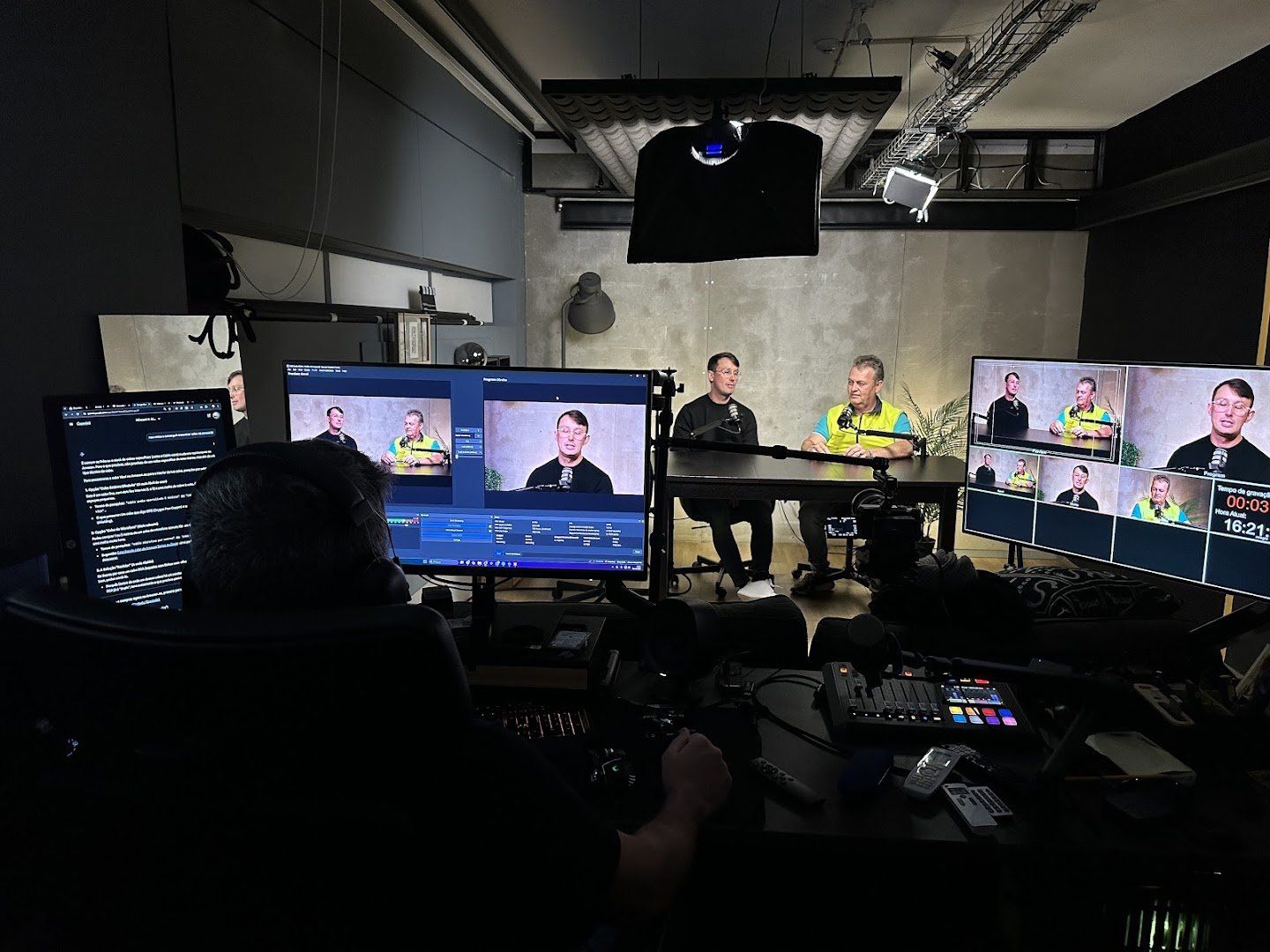 Régie do estúdio de podcast do Synergy Hub com monitores multicâmara durante uma gravação